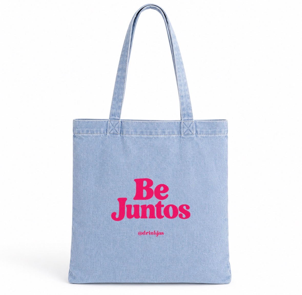 Light-wash denim JAS tote bag printed with Be Juntos and @drinkjas in hot pink